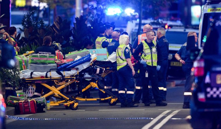 Police officers and emergency service workers are seen at Bondi Junction after multiple people were stabbed